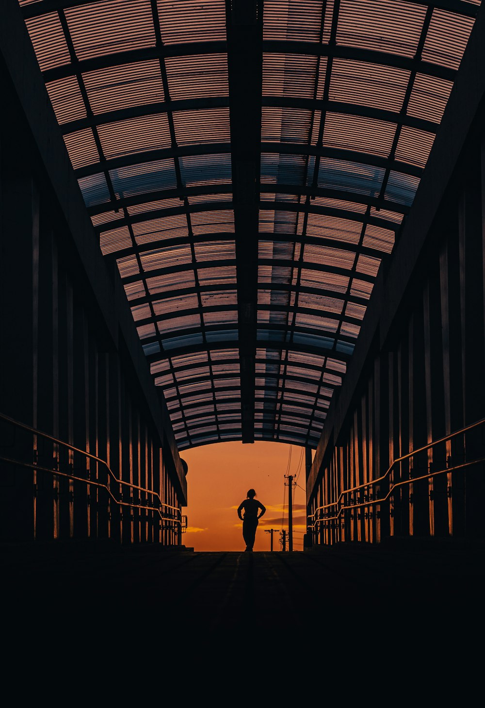 a silhouette of a person standing in a train station