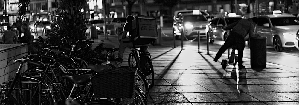 a man riding a bike down a street next to parked cars