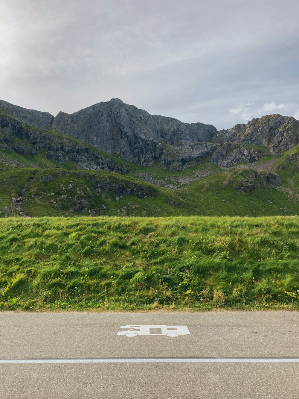 an empty road in front of a mountain range