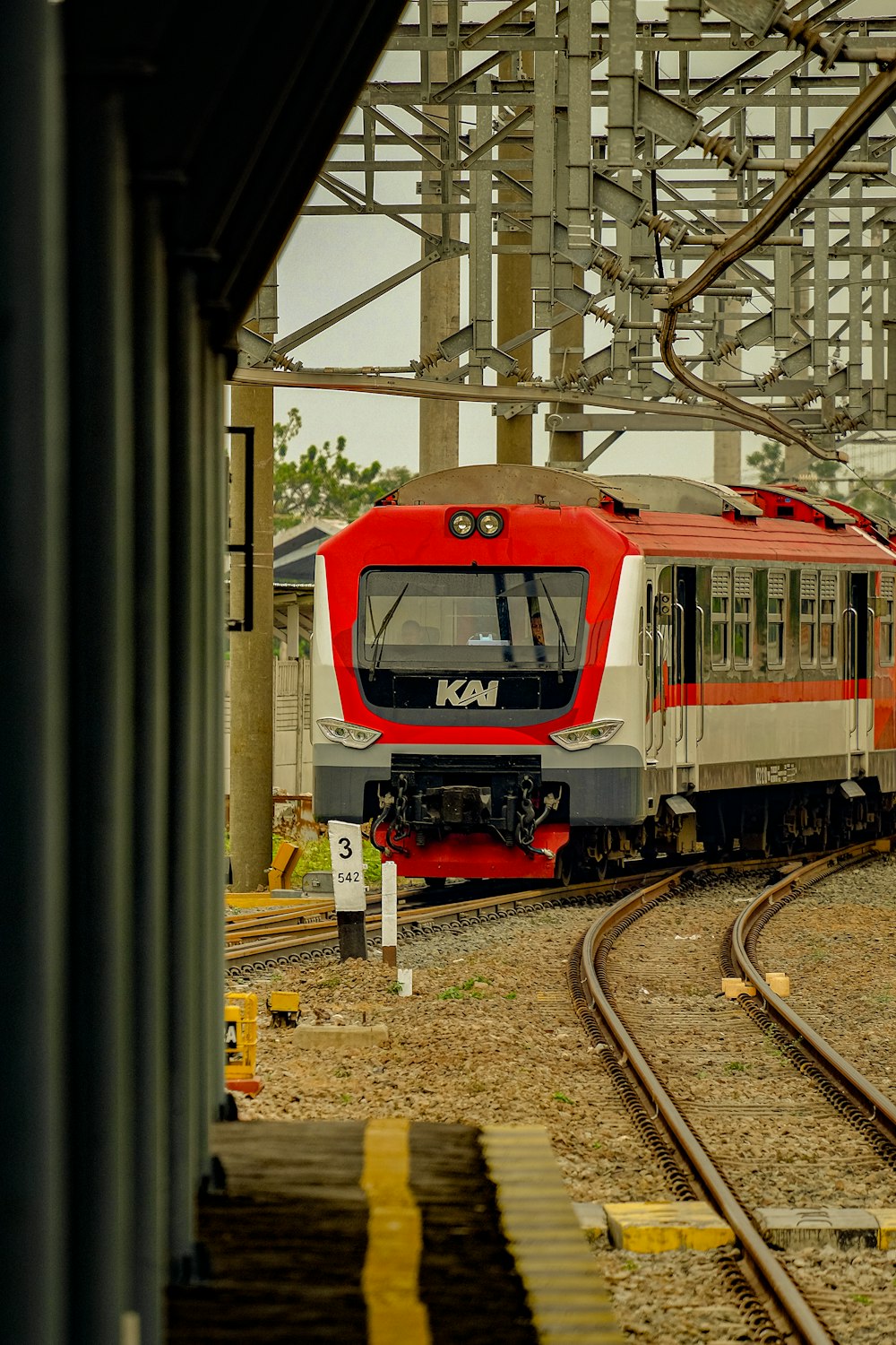 a red and white train traveling down train tracks