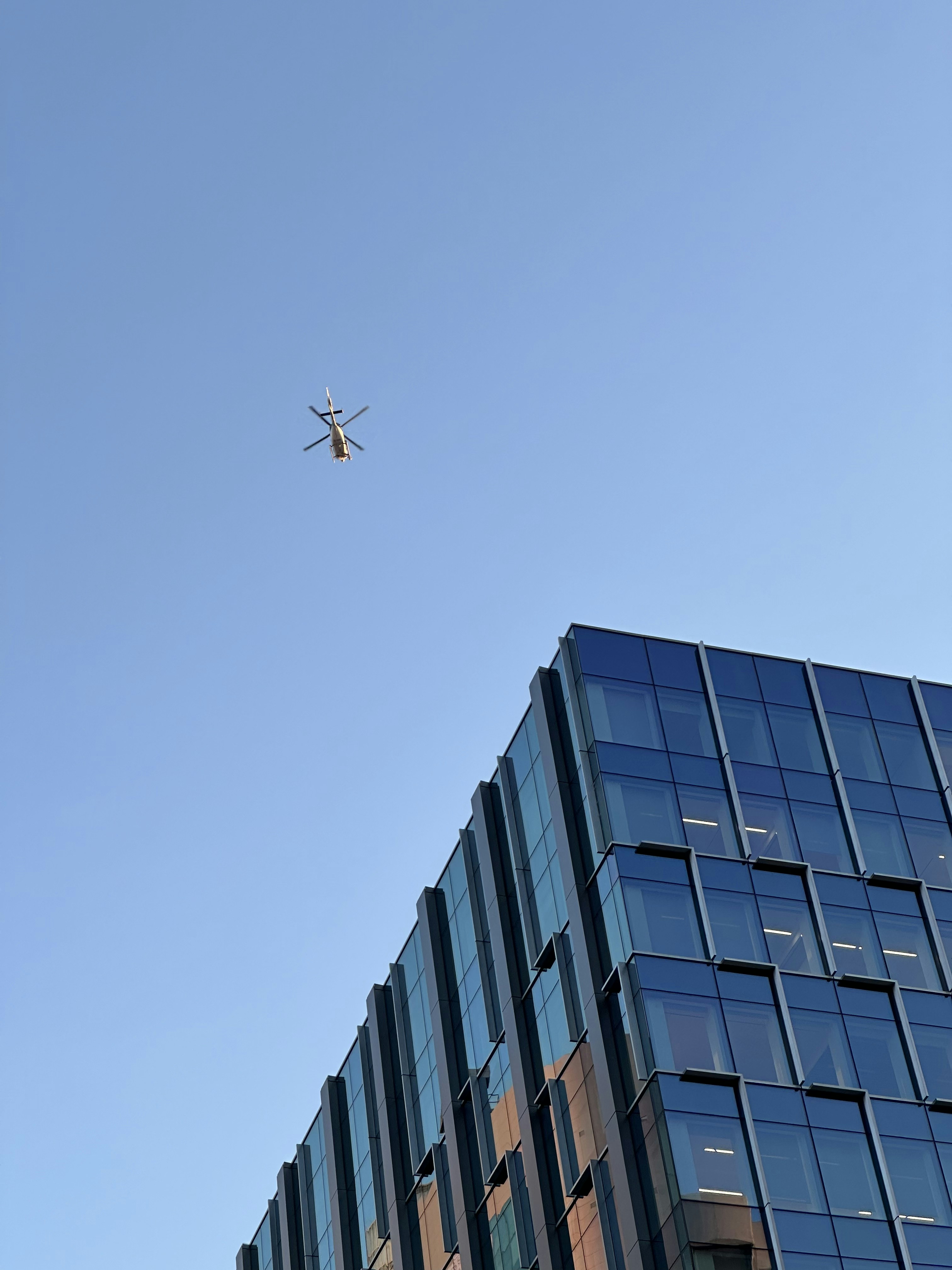 a plane flying in the sky over a building