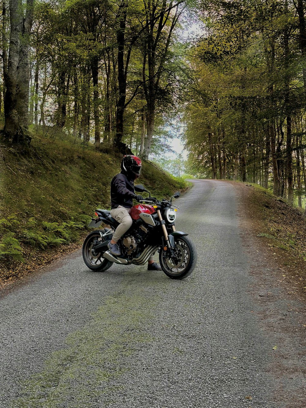 a man riding a motorcycle down a country road