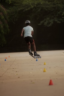 a man riding a skateboard down a street next to cones