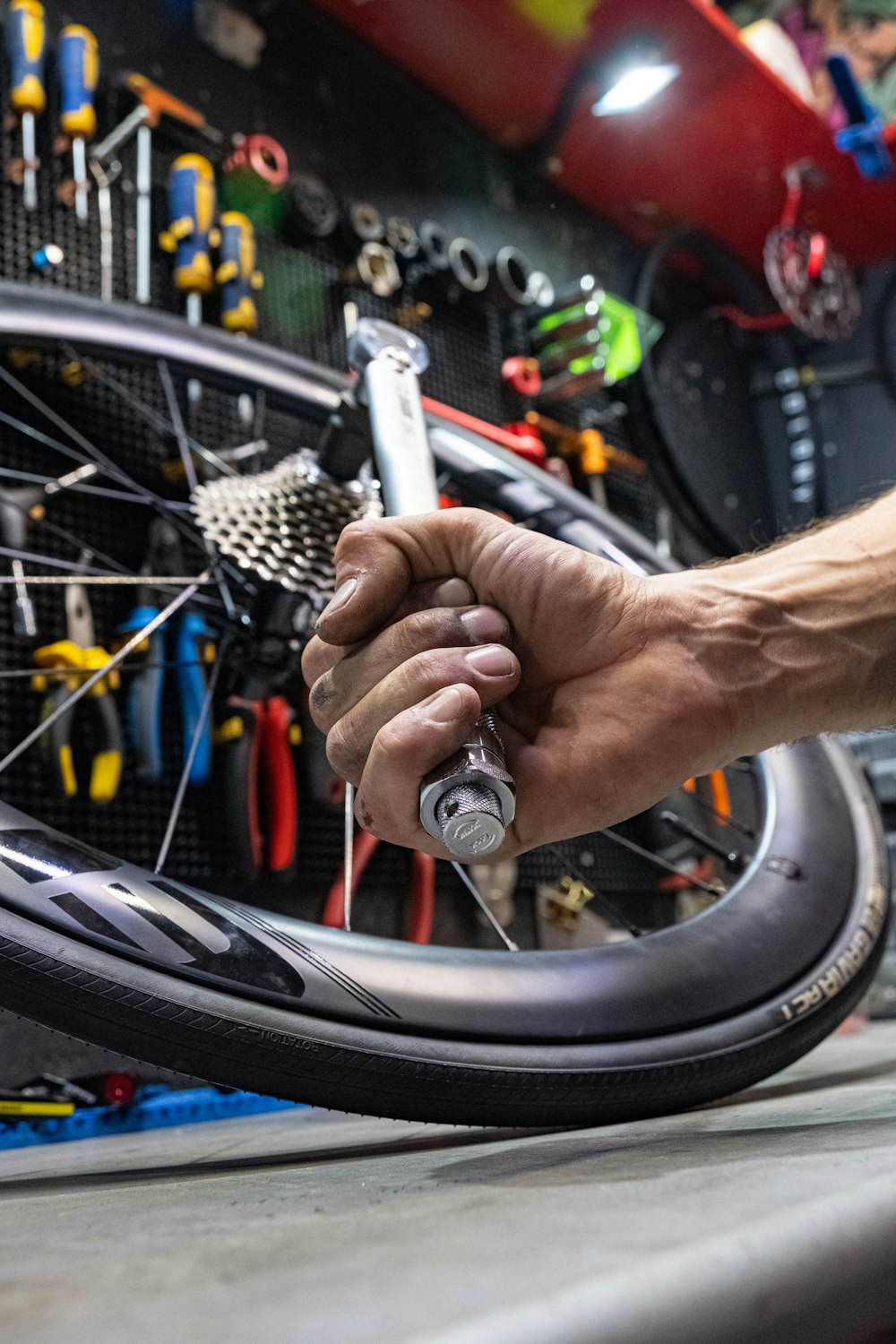 a man working on a bicycle wheel with a wrench