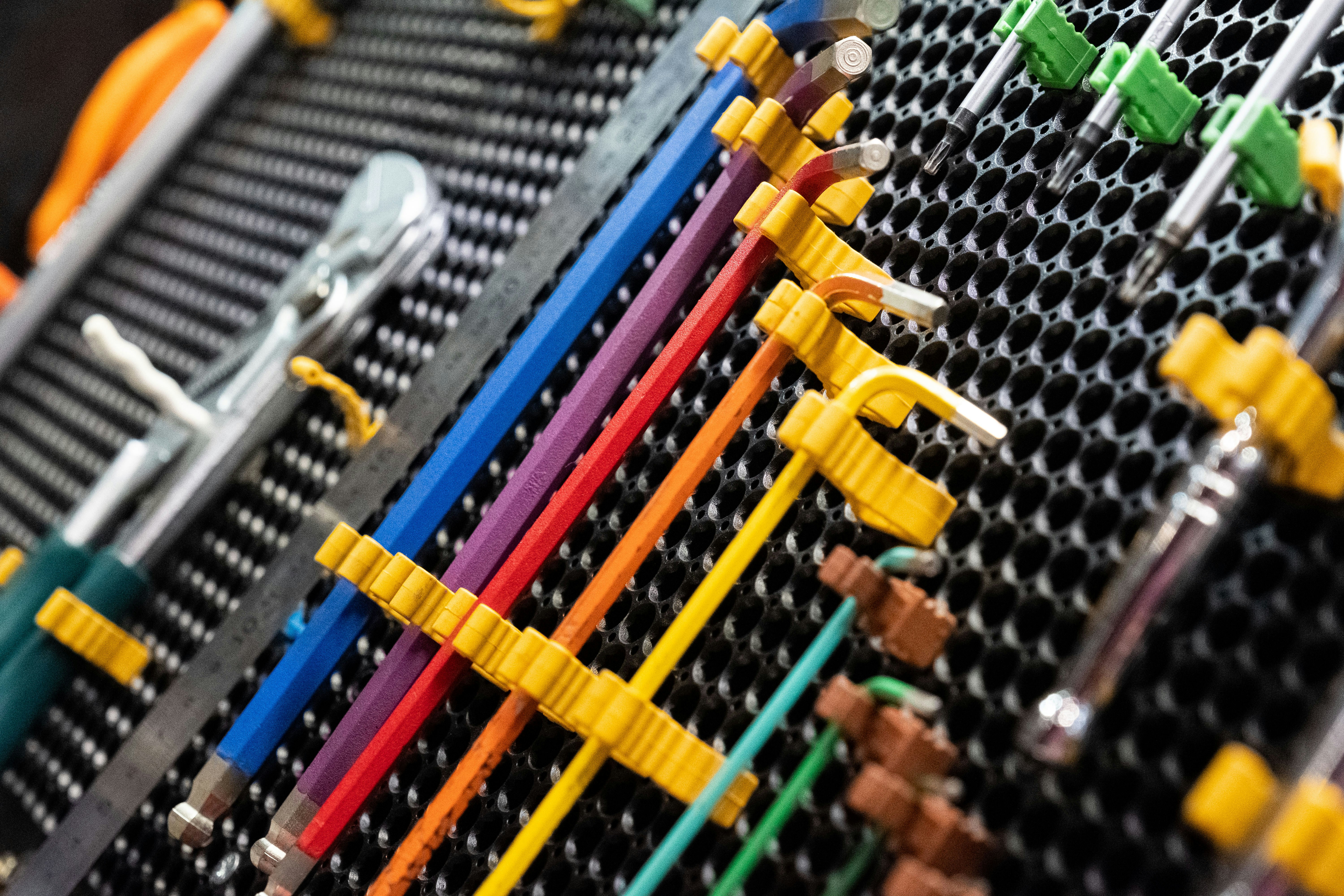 multi-colored instrument hanging on a peg board