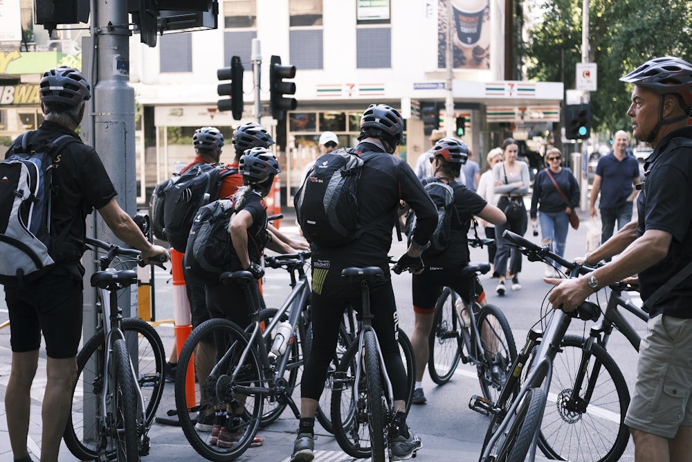 a group of bicyclists waiting at a traffic light