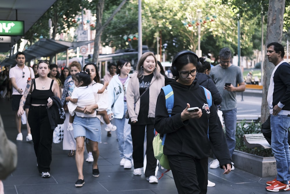 a group of people walking down a sidewalk