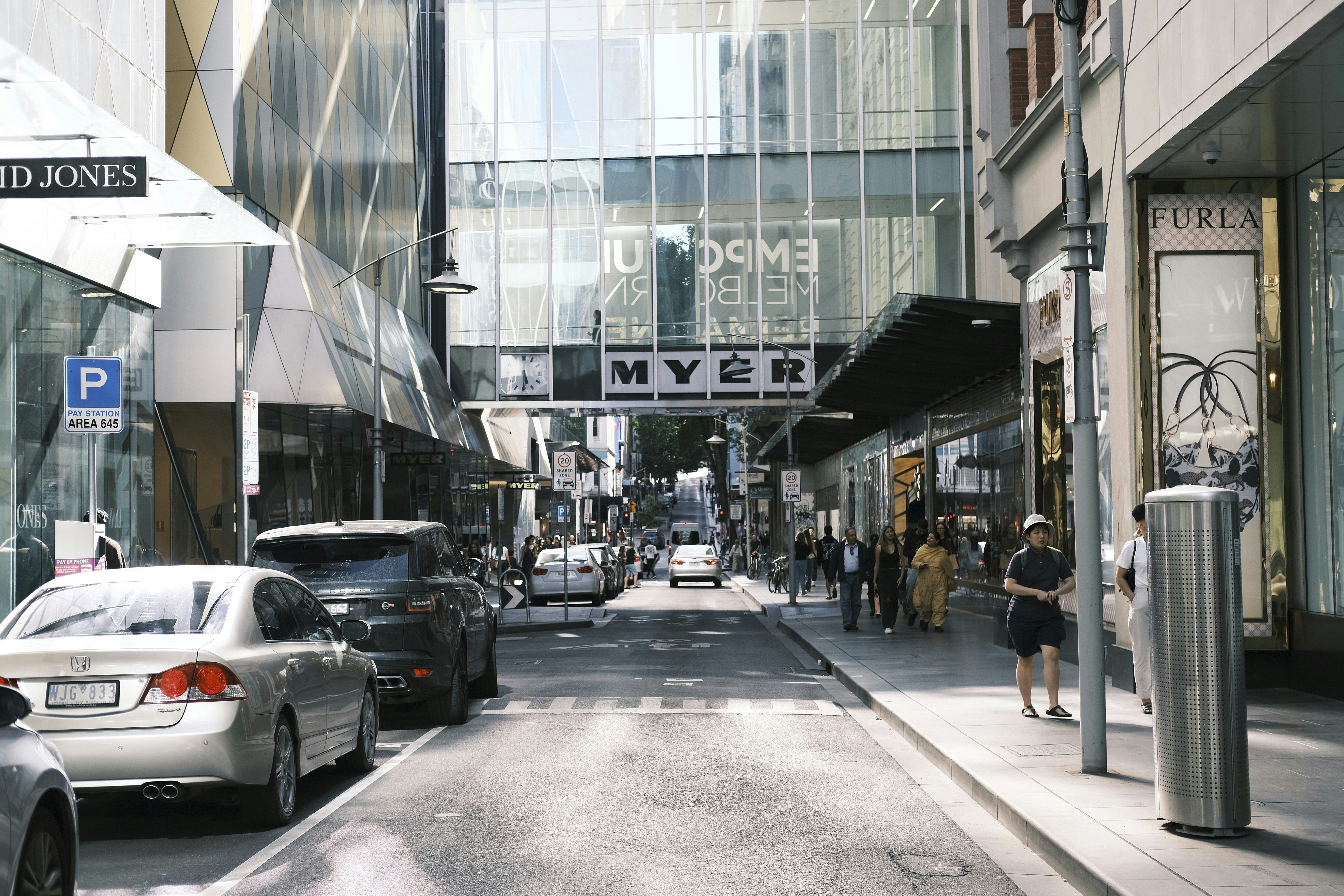 a city street filled with lots of traffic next to tall buildings, 