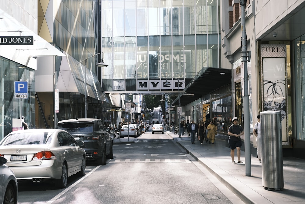 a city street filled with lots of traffic next to tall buildings