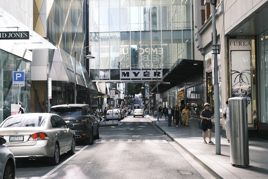 a city street filled with lots of traffic next to tall buildings,