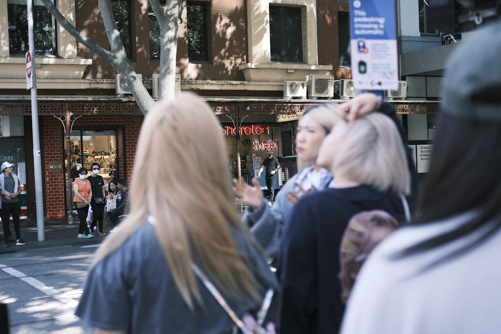 a group of people standing on a street corner