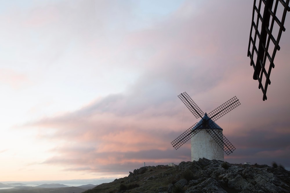 a windmill sitting on top of a rocky hill