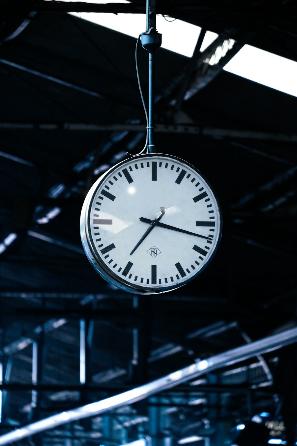 a clock hanging from the ceiling of a building