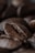 A close-up of coffee beans on a wooden table, highlighting their rich texture.