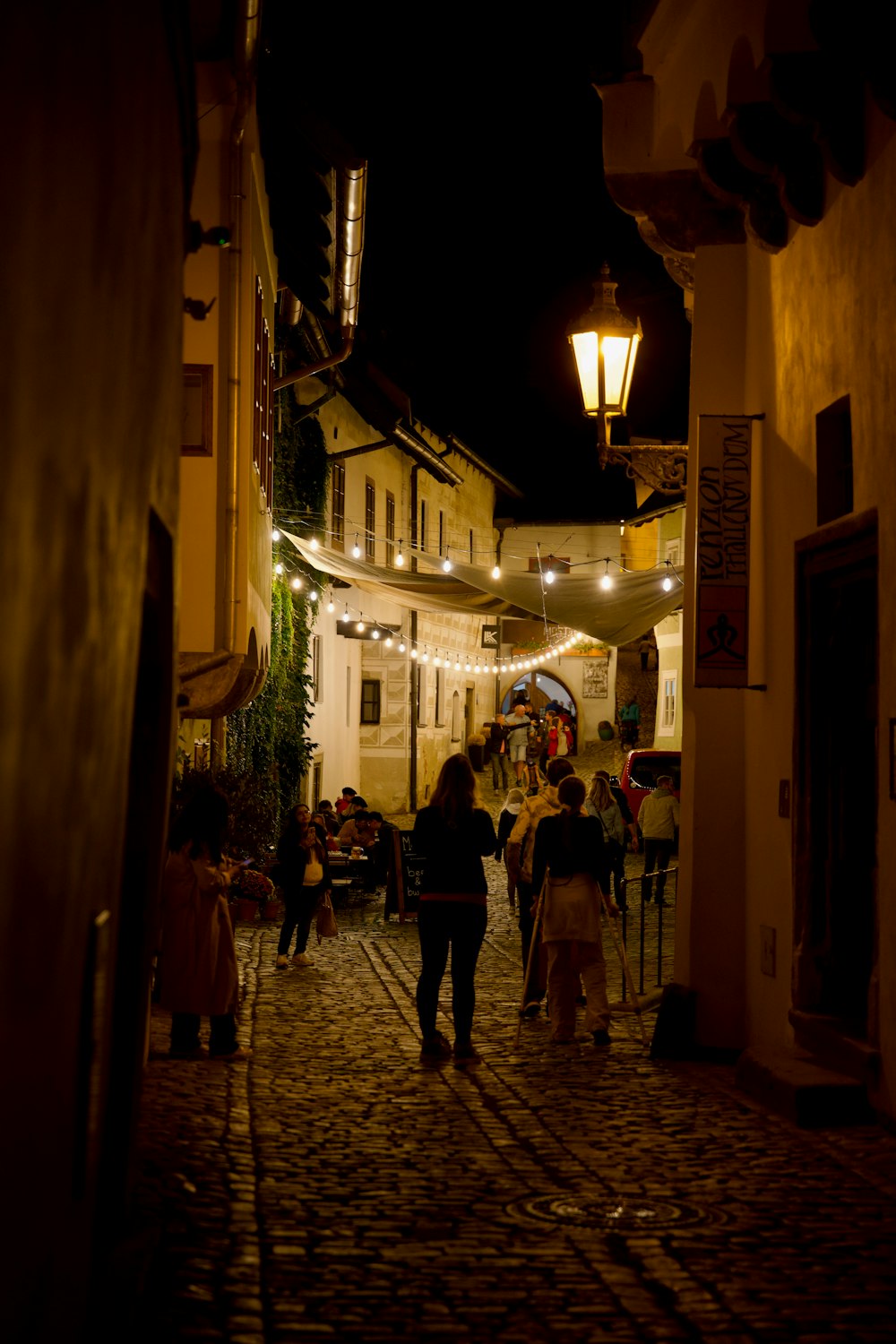 a group of people walking down a street at night