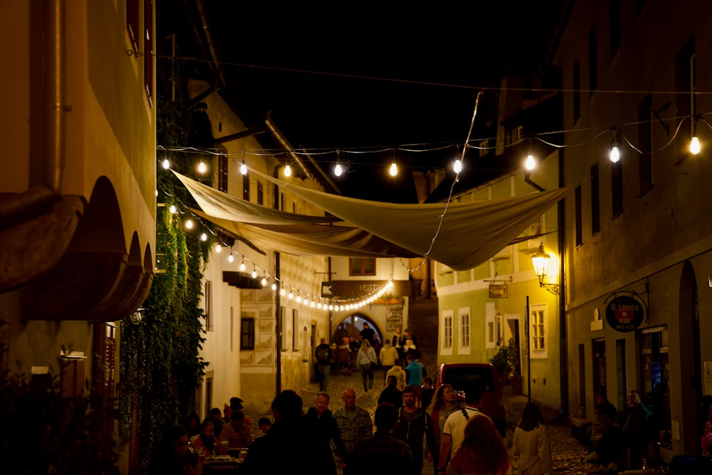 a group of people walking down a street at night