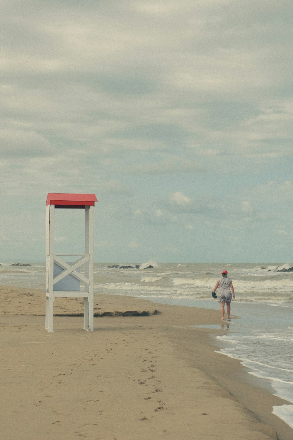 a man walking along a beach next to the ocean