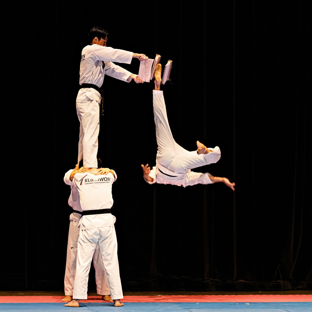 a couple of men standing on top of each other on a stage