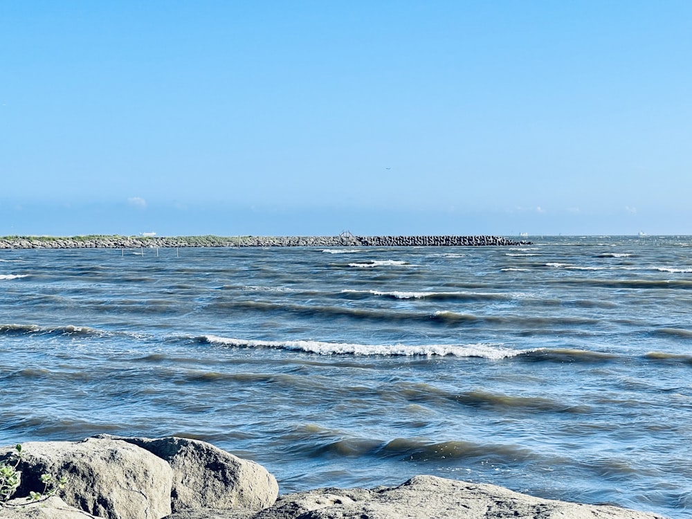 une vue d’un plan d’eau avec des rochers au premier plan