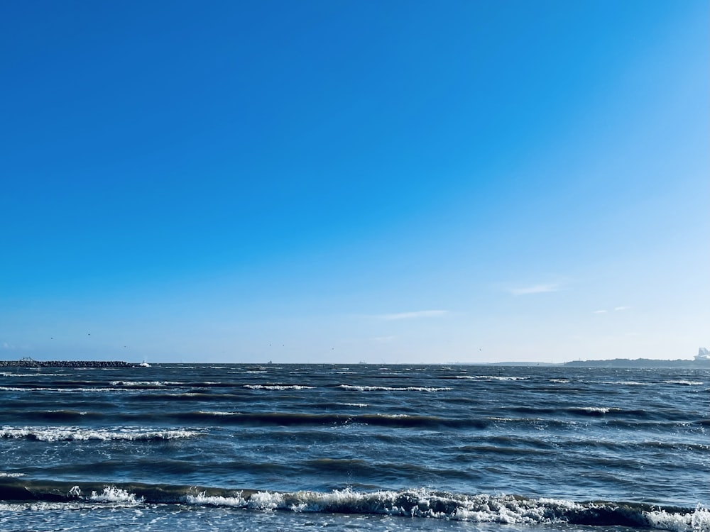 a large body of water sitting under a blue sky