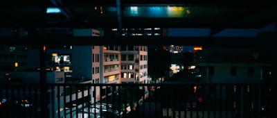 Night view of a penthouse terrace with city lights in the background.