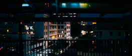 Evening cityscape of Cusco seen from a balcony with warm ambient lighting.
