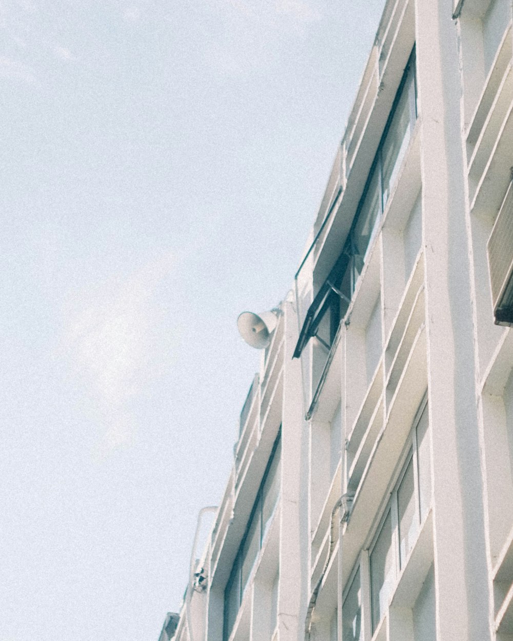 a tall white building sitting next to a traffic light