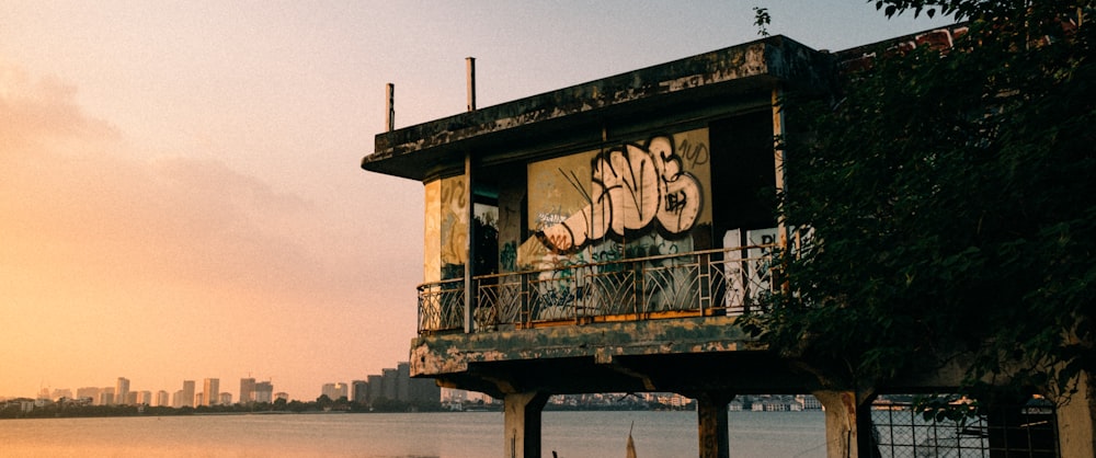 a tall building with graffiti on it next to a body of water