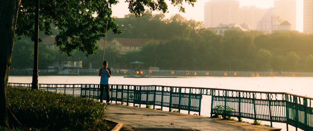 a person standing on a bridge looking at the water