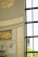A close-up of a beautifully framed Arabic calligraphy print hanging on a beige wall with soft natural light.