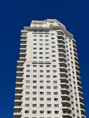 a tall white building with windows and balconies
