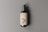 A dark amber glass pump bottle is positioned against a neutral gray background. The bottle features a cream-colored label with bold black text that reads 'PSD'. The pump on top is a matte black color, and the shadow cast suggests a light source from the left.