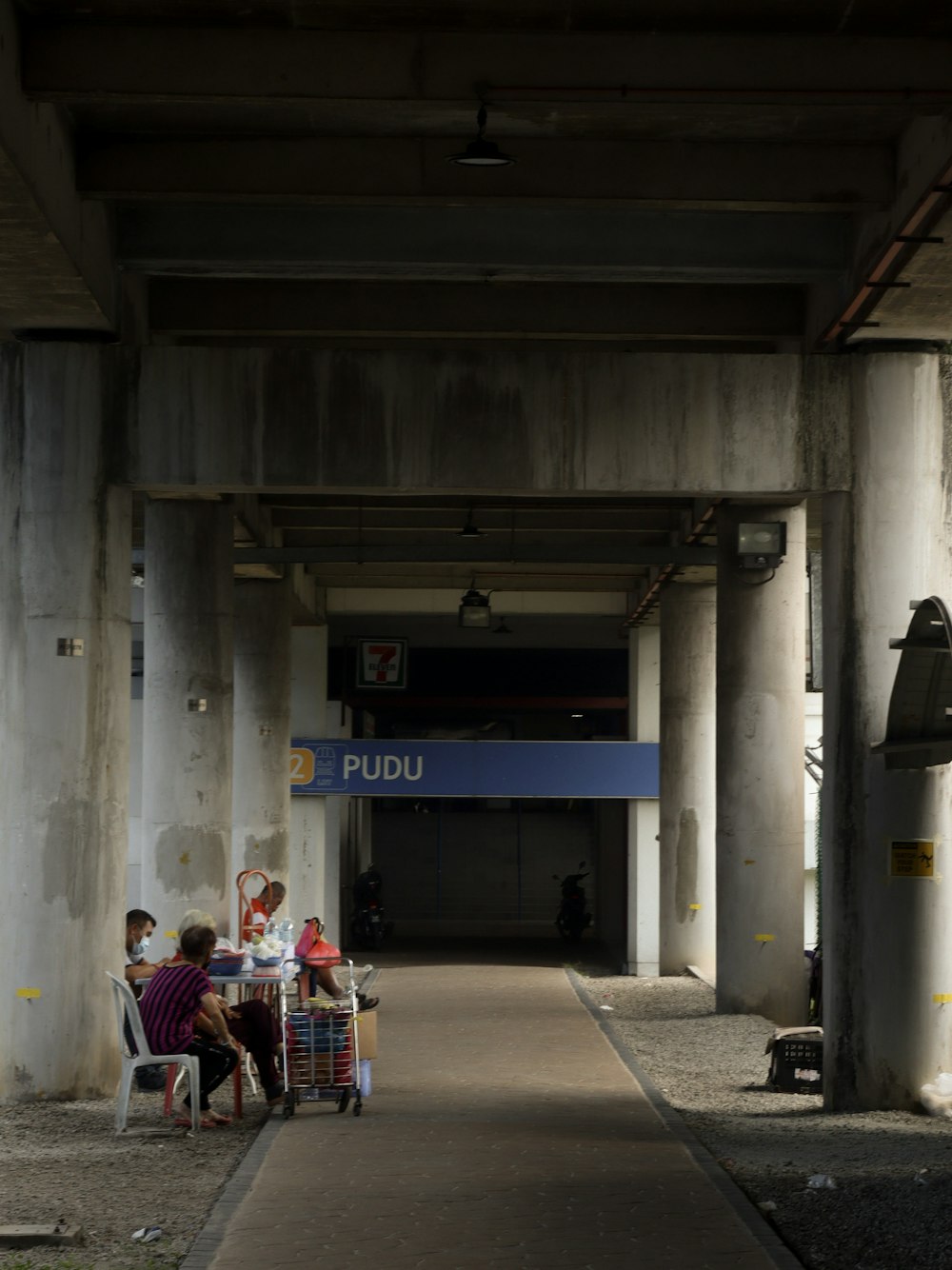 a group of people sitting at a table under a bridge