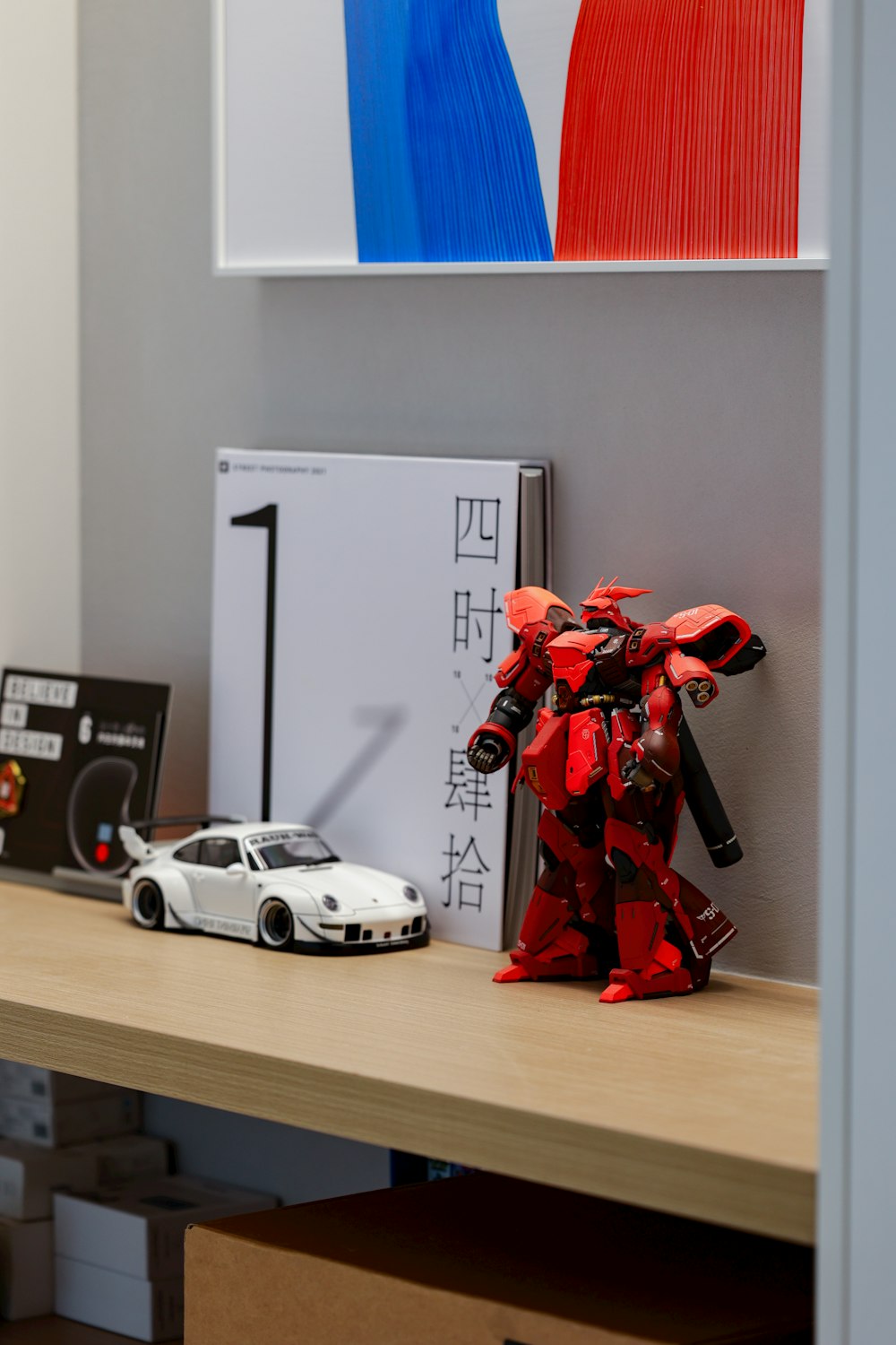 a toy car sits next to a toy robot on a desk