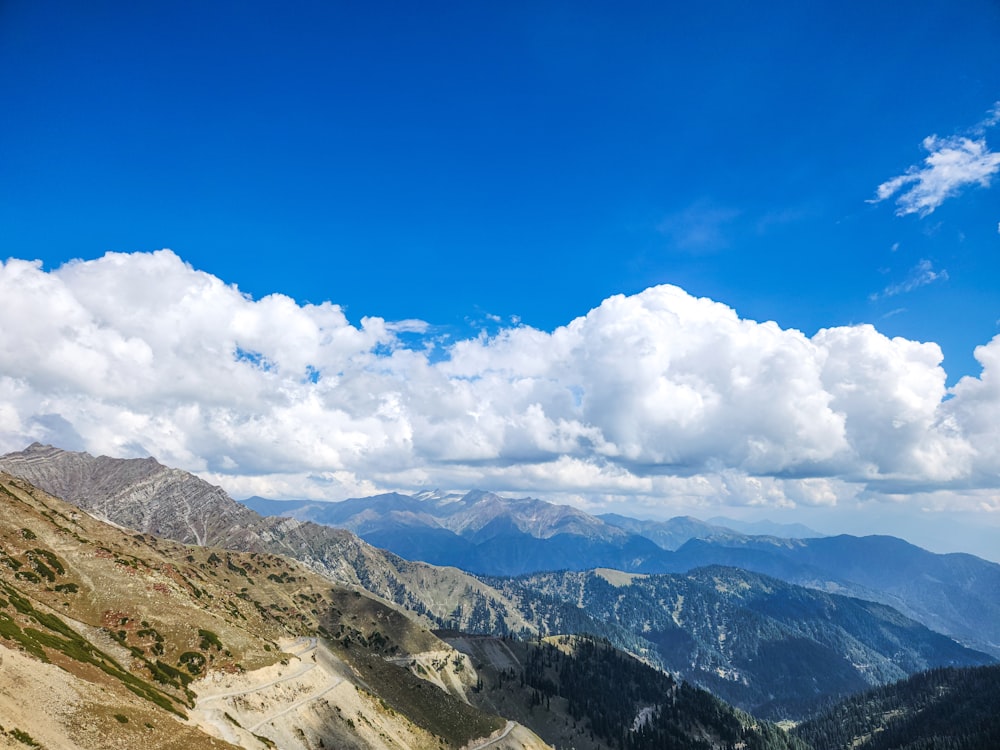 a scenic view of a mountain range with clouds in the sky