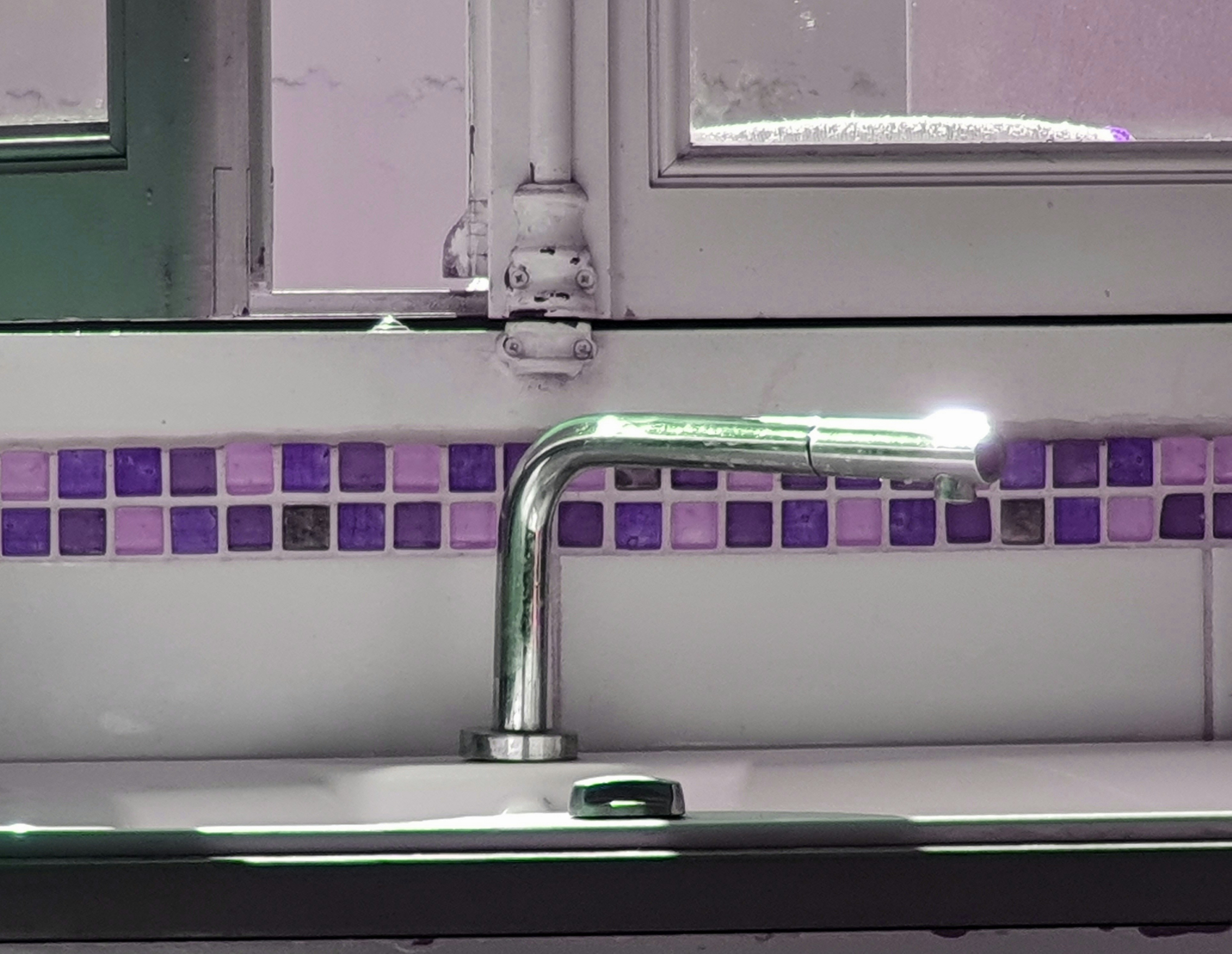 a bathroom sink with a faucet and a mirror above it