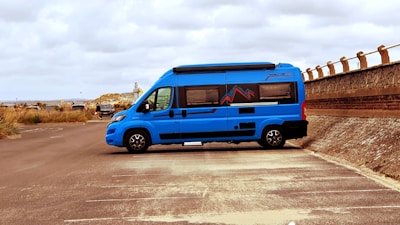A vibrant blue commercial van ready for work, parked on the lot with clear branding.