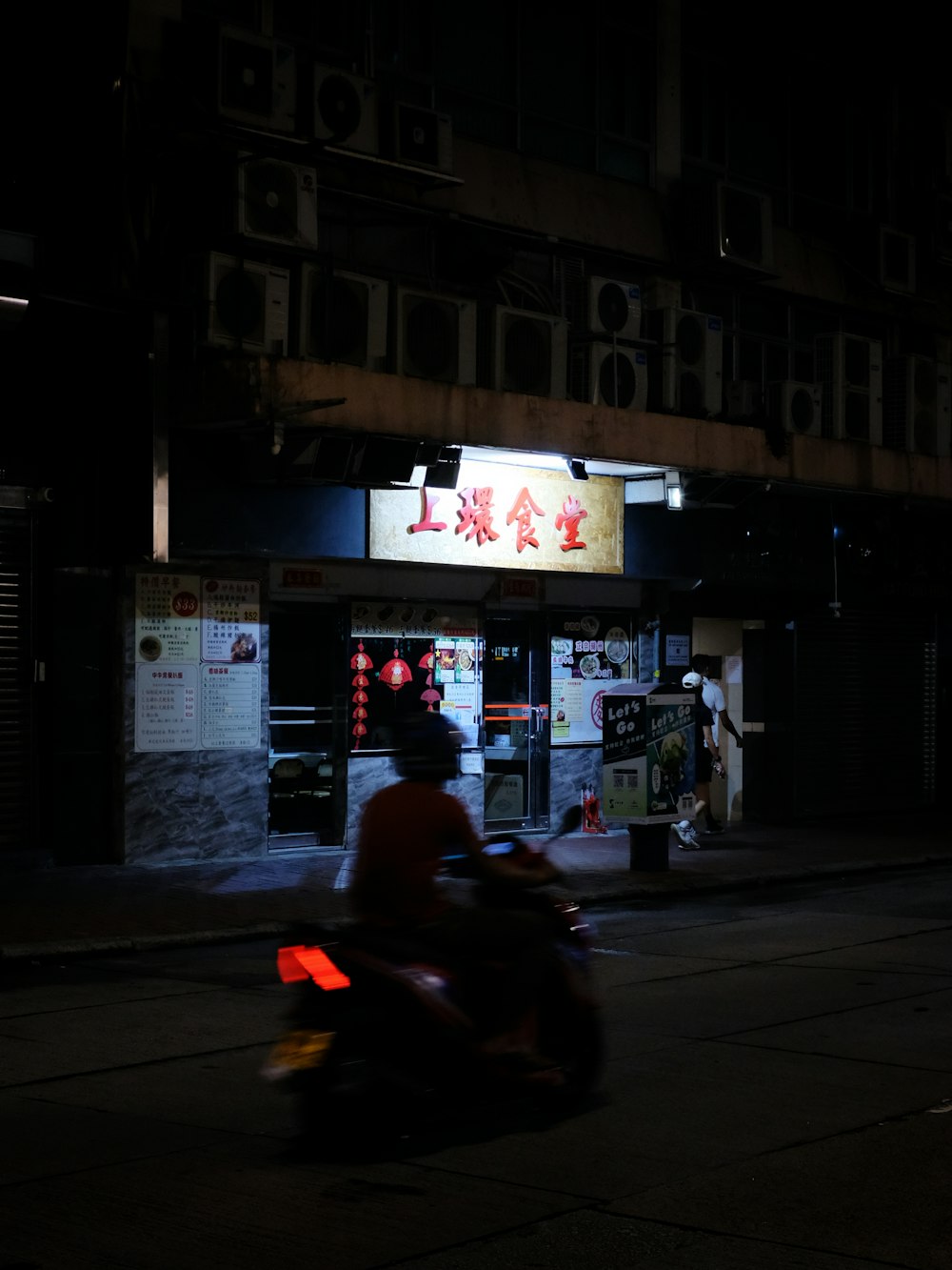 Un homme conduisant une moto dans une rue la nuit