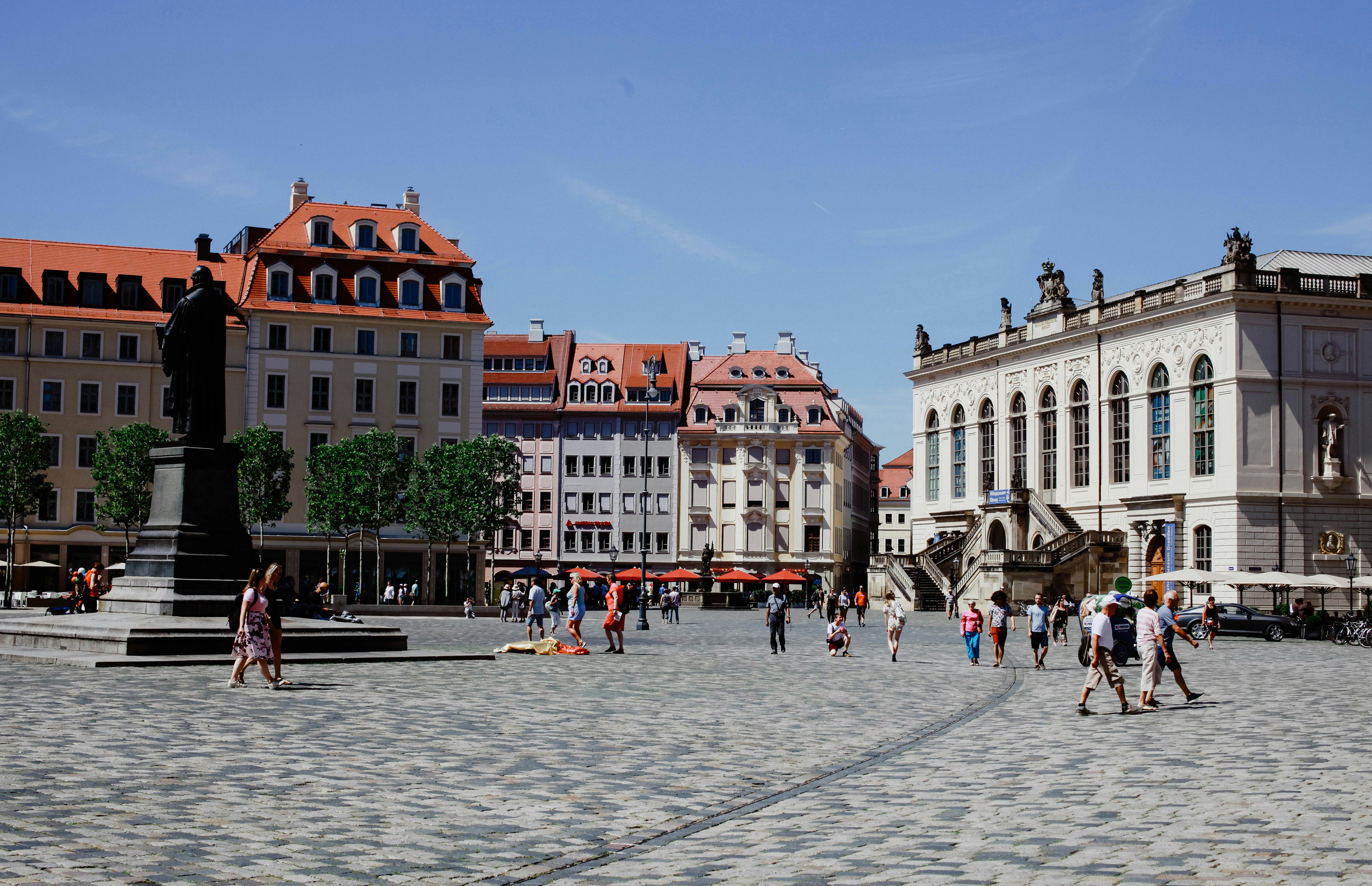 a group of people walking around a city square