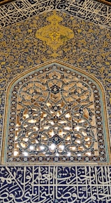 Close-up of intricate Islamic geometric patterns carved into a historic mosque wall.
