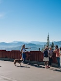 a group of people standing next to a red fence