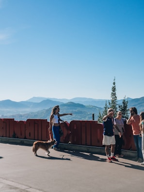 a group of people standing next to a red fence