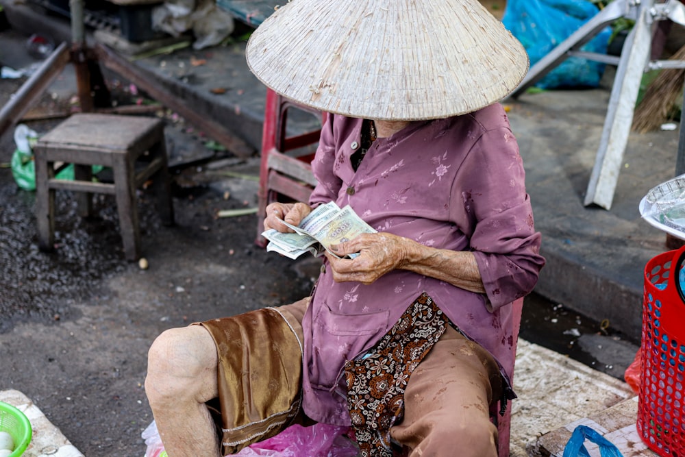 a woman sitting on the ground with a hat on her head