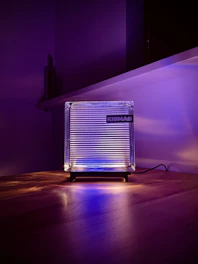 Close-up of a glowing LED acrylic lamp with an intricate personalized design, radiating warm light on a wooden table.