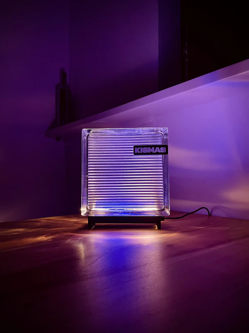 Custom acrylic LED lamp glowing softly beside a personalized engraved plaque on a styled event table