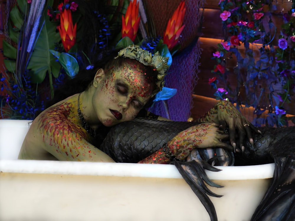 a woman in a bathtub covered in body paint