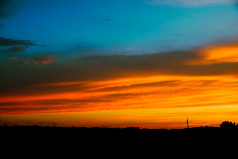 a plane flying in the sky at sunset