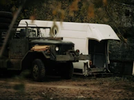 Silver pickup truck loaded with gear, set against a rugged outdoor backdrop.