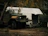 A rugged heavy-duty truck parked outside a Veloceforta service center with technicians working on it.