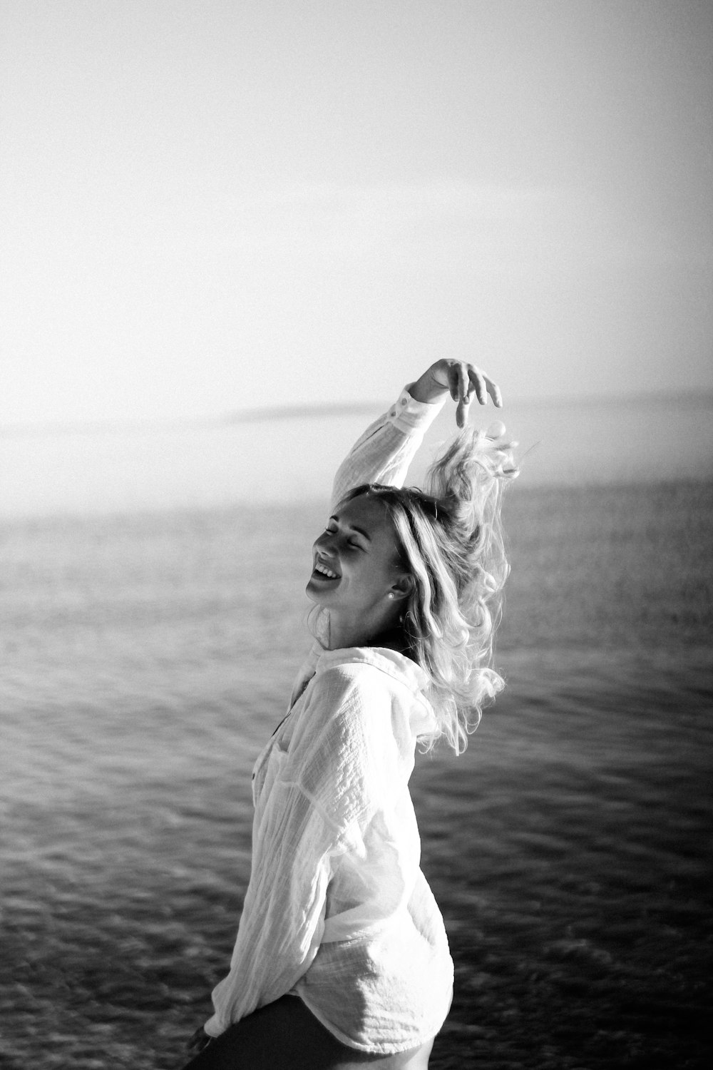 a woman standing on top of a beach next to the ocean